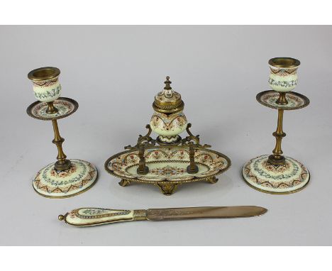 A Continental enamelled desk set comprising two candlesticks, an inkwell and pen holder, and a letter opener, all with floral