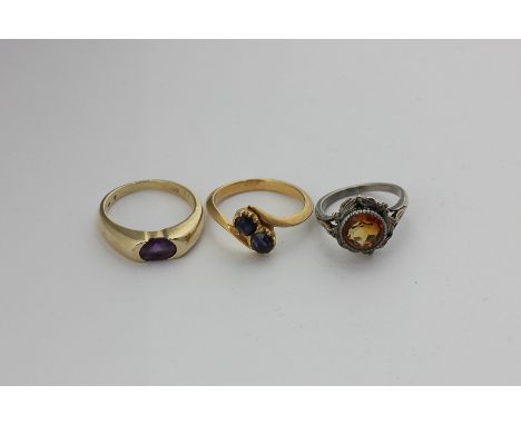 A sapphire two-stone crossover ring, an amethyst ring in 14ct gold, and a citrine ring in silver and gold