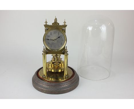 A Gustav Becker brass anniversary clock, the circular dial with Arabic numerals, under a glass dome, clock 22cm high, with ke
