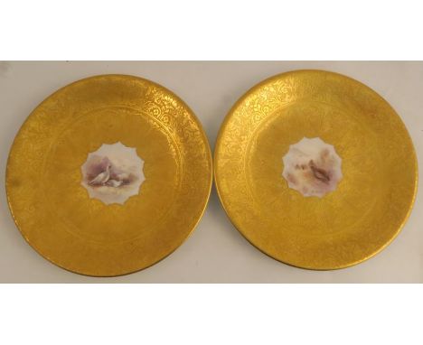 A pair of Royal Worcester acid gilt plates, painted to the centre with Ptarmigan and Partridge by Jas Stinton, signed, diamet