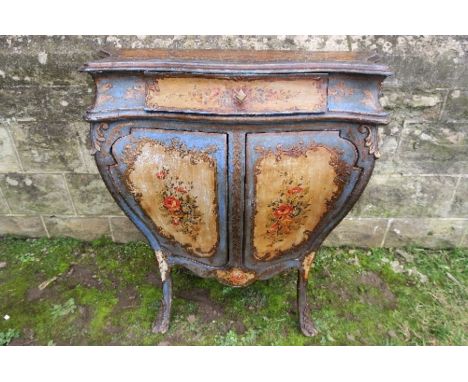 A painted Venetian style bombe commode, fitted with a drawer, with cupboard doors below, raised on outwept feet, decorated wi