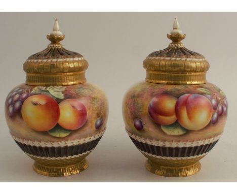 A pair of Royal Worcester covered pot pourri vases, with inner covers, hand painted half round with fruit, and to the reverse