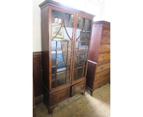 A late 19th century mahogany glazed cabinet, having two astragal glazed doors opening to revel adjustable shelves, with two b