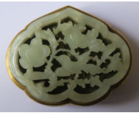 A Chinese jade leaf shaped mounted buckle, pierced and decorated with birds and foliage, having a gilt metal mount, width 2.7