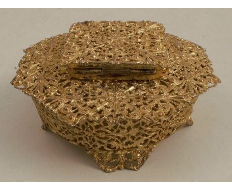 A silver gilt pierced inkwell, decorated in a filigree style, with square hinged lid to the circular base, raised on fur lug 