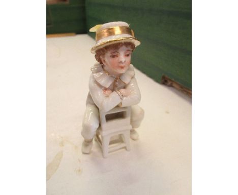 A 19th century Royal Worcester Kate Greenaway style figure, of a young boy seated the wrong way on a chair, height 3.75ins - 