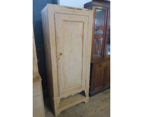 A pine cupboard, the door opening to reveal shelf, raised on a shaped frieze with shelf below, width 30ins x depth 17ins x he