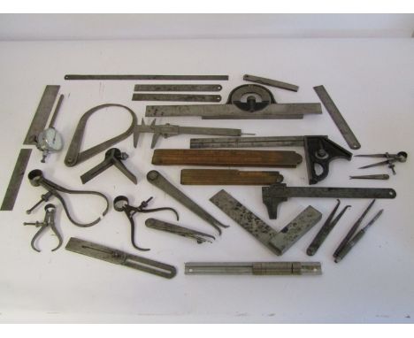 A box of measuring and marking tools including wooden and steel rukes, scribers, squares, calipers, dividers, verniers etc