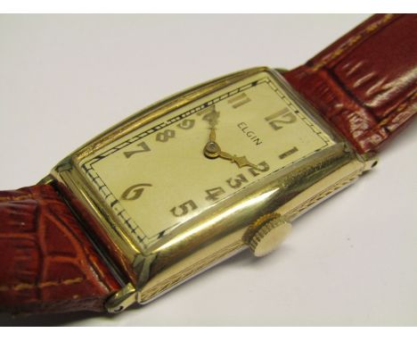 ELGIN: A 1930's gold plated and steel cased gent's manual wind wristwatch of curvex form, silvered dial with gilt Arabic nume