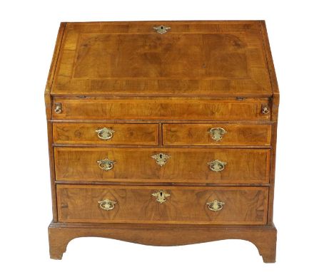 A George I Walnut and Featherbanded Bureau, early 18th century, the fall front enclosing a good fitted interior of pigeons ho