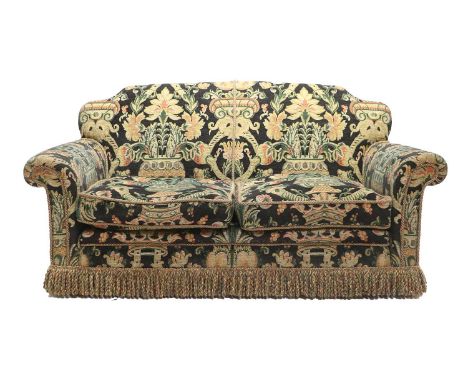 A Two-Seater Sofa, recovered in dark blue polychrome floral fabric, with two squab cushions above a tasselled base, on carved