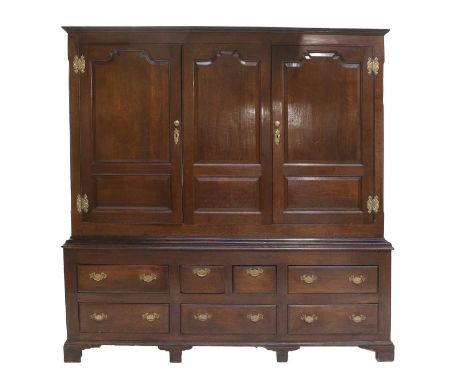 A George III Oak Livery Cupboard, 2nd half 18th century, the moulded cornice above fielded panels and two cupboard doors, the
