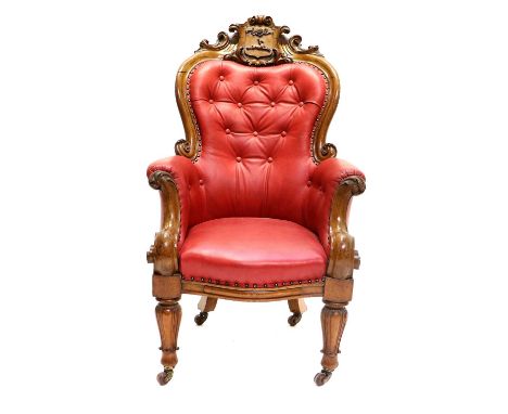 A Victorian Carved Oak Library Armchair, 3rd quarter 19th century, covered in close-nailed buttoned red leather, the moulded 