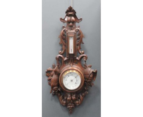 Aneroid Barometer and thermometer within Black forest style oak surround, the high relief carving incorporating fruit and gam