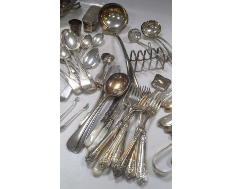 A three division cutlery tray of assorted silver flatware together with a silver toast rack, 657g (21ozt) gross, along with a