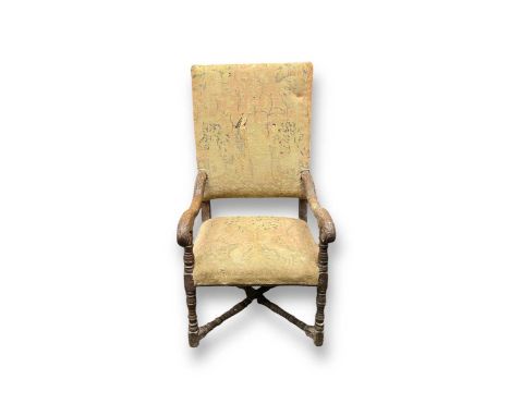 A Baroque style carved oak armchair, the tapestry covered back and seat depicting animals and maidens in a forest,the leaf ca