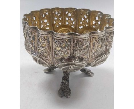 A Middle Eastern metalwares circular lidded box, 75mm diameter; an Indian bonbon dish on three legs, 78mm diameter, and a sil
