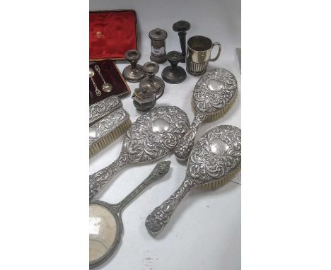 A silver christening mug, some cased silver flatware, a silver cased pepper grinder, three dwarf candlesticks, a five piece s