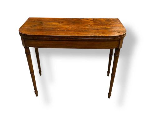 A Regency rosewood demi-lune card table raised on ring turned and tapered legs, 74 x 91 x 45cm closed and 74 x 91 x 91cm open