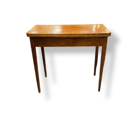 A George III mahogany card table the canted rectangular top with satinwood stringing, set on square tapered legs, 74 x 81 x 4
