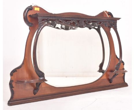 An Art Nouveau early 20th century mahogany &amp; ebonised wood overmantel wall mirror. The mirror having a shaped frame with 