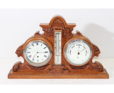 A 19TH CENTURY CARVED OAK DESK WEATHER STATION, inset with a clock, thermometer and barometer. 53cm wide