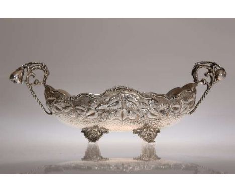 AN AMERICAN STERLING SILVER CENTREPIECE, early 20th Century, the oval bowl repousse with fruiting and flowering vine above a 