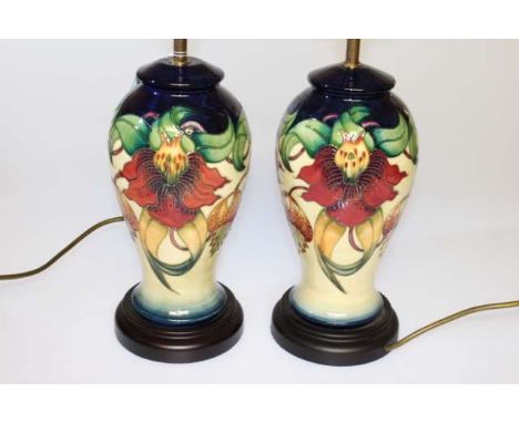 A PAIR OF MOORCROFT POTTERY LAMP BASES, of baluster form, each decorated with the "Anna Lily" pattern by Nicola Slaney. 38cm 