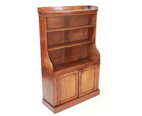 A REGENCY MAHOGANY WATERFALL BOOKCASE, with open shelves above a pair of panel doors, raised on a plinth base. 145.5cm by 92c
