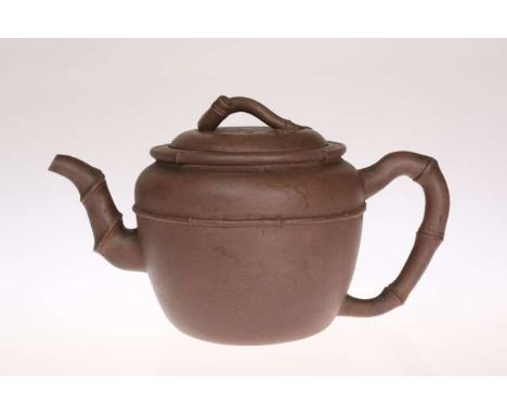 A CHINESE YI-HSING TEAPOT, naturalistically modelled with bamboo-moulded handle, spout and knop, moulded mark to base. 13cm