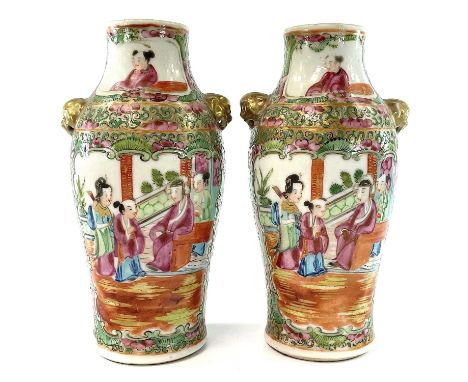 A pair of Chinese Canton porcelain vases, 19th century, each with a panel enclosing figures in an interior setting, opposed b