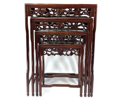 A Chinese hardwood quartetto nest of tables, early 20th century, each carved with fruit and leaves, largest height 72cm, 52cm