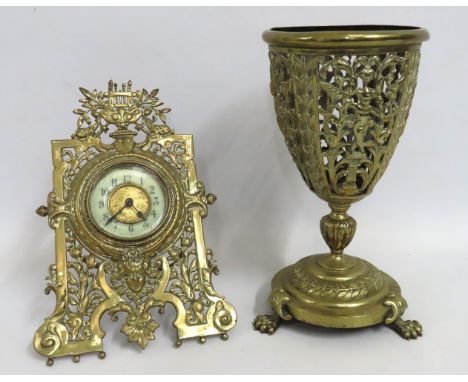 A brass open work oil lamp base twinned with a brass mounted clock, tallest 305mm