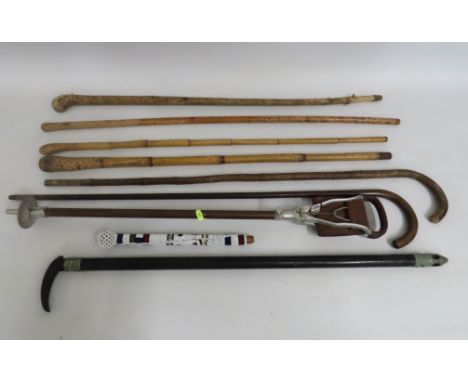 A selection of walking canes, a Bekko light up cane, a shooting stick & top of an African beaded cane