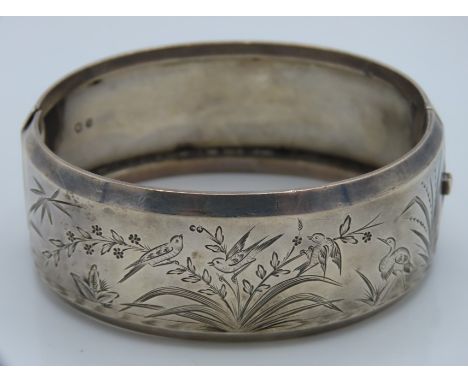 An 1880 Victorian Birmingham silver bangle with organic decor, internal measurement 58mm x 48mm, 39.3g