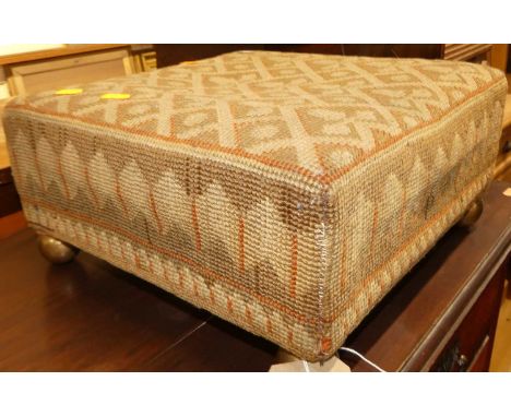 A late Victorian tapestry upholstered square low footstool, raised on gilt metal ball feet, 37 x 36cm