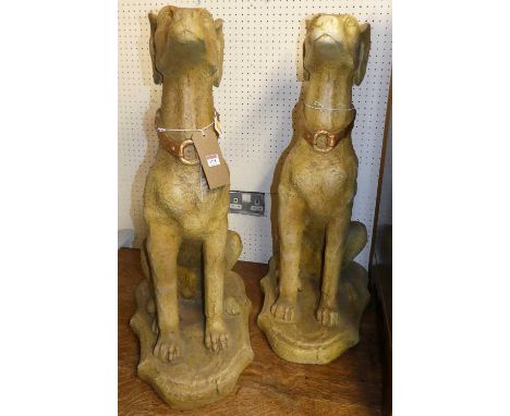A pair of painted composite seated hunting hounds raised on integral shaped bases, height 80cm