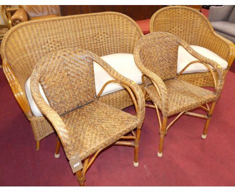 A wicker two-piece conservatory suite, comprising; two-seater sofa, single armchair, together with a further near pair of wic