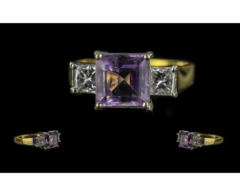 18ct Gold Dress Ring, central Amethyst surrounded by two princess cut diamonds.  Ring size R, fully hallmarked.  Weight 5.4 g