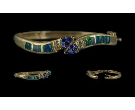 14ct Gold - Excellent Quality Tanzanite and Diamond Set Double Snake Head Hinged Bangle. Marked 14ct to Interior of Shank. Th