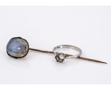 A platinum ring mount missing stone, 3g, together with a gilt metal opalescent stick pin (2) 