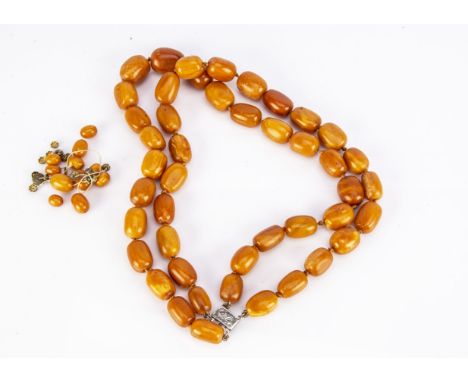 A double row of flattened oval shape butter-scotch amber bead necklace,  on a white metal clasp marked 925, various loose ova