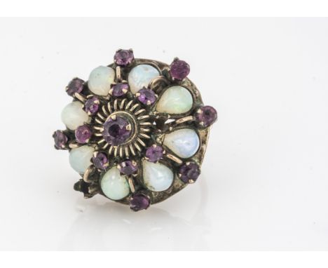 An Indian and ruby raised cluster ring, of circular design, set with pear shaped opals and small mixed circular cut rubies, r