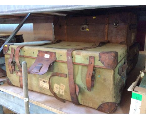 A vintage canvas and leather mounted trunk; another similar and a battened example with some attached luggage labels, (3)
