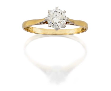 An 18 Carat Gold Diamond Solitaire Ring, the round brilliant cut diamond in a white claw setting, to a yellow tapered shoulde