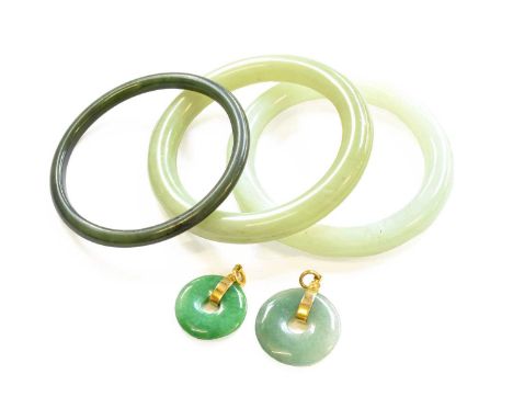 Two Jade Type Bangles, inner diameter 5.8cm; A Nephrite Bangle, inner diameter 6.0cm; and Two Jade Type Pendants, lengths 3.4