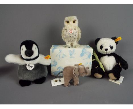 Steiff - four Steiff animals comprising Manschli Panda with tags and button in ear with yellow label, Charly Pinguin with tag