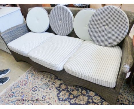   A contemporary all weather rattan three seater sofa and cushions. W-200cm, D-74cm, H-83cm.