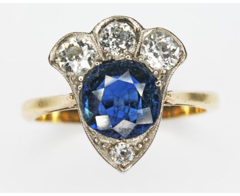 A diamond and sapphire cluster ring, the central round cut sapphire weighing approx. 1.23cts, four millegrain set old cut dia