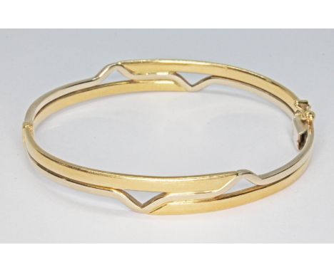 A two colour bangle, marked '750', diameter 6cm, wt. 15.2g.  